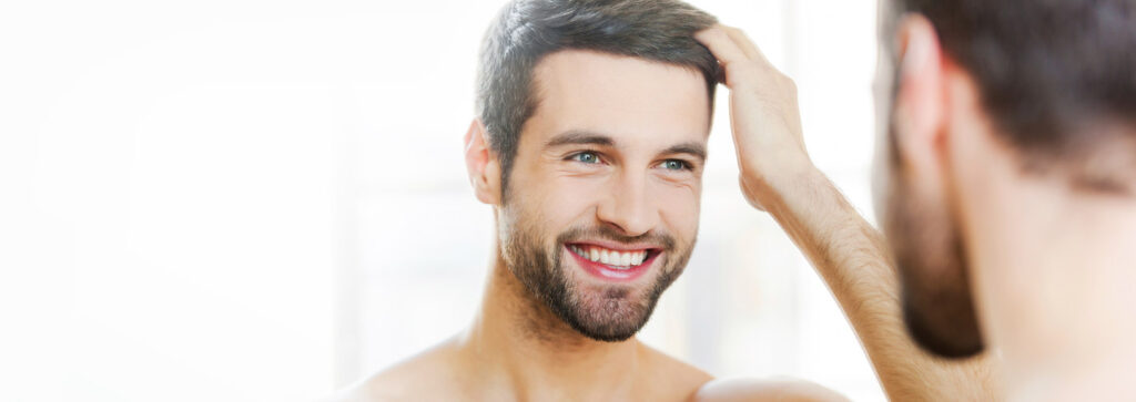 Smiling man after successful hair transplant in Rawalpindi at De Nova Aesthetic Clinic showing natural and permanent results.